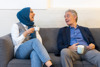 A female and male having a conversation on a couch
