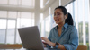 A Woman Wearing Earphones Talking On A Laptop