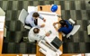 Three People Sat Around A Desk