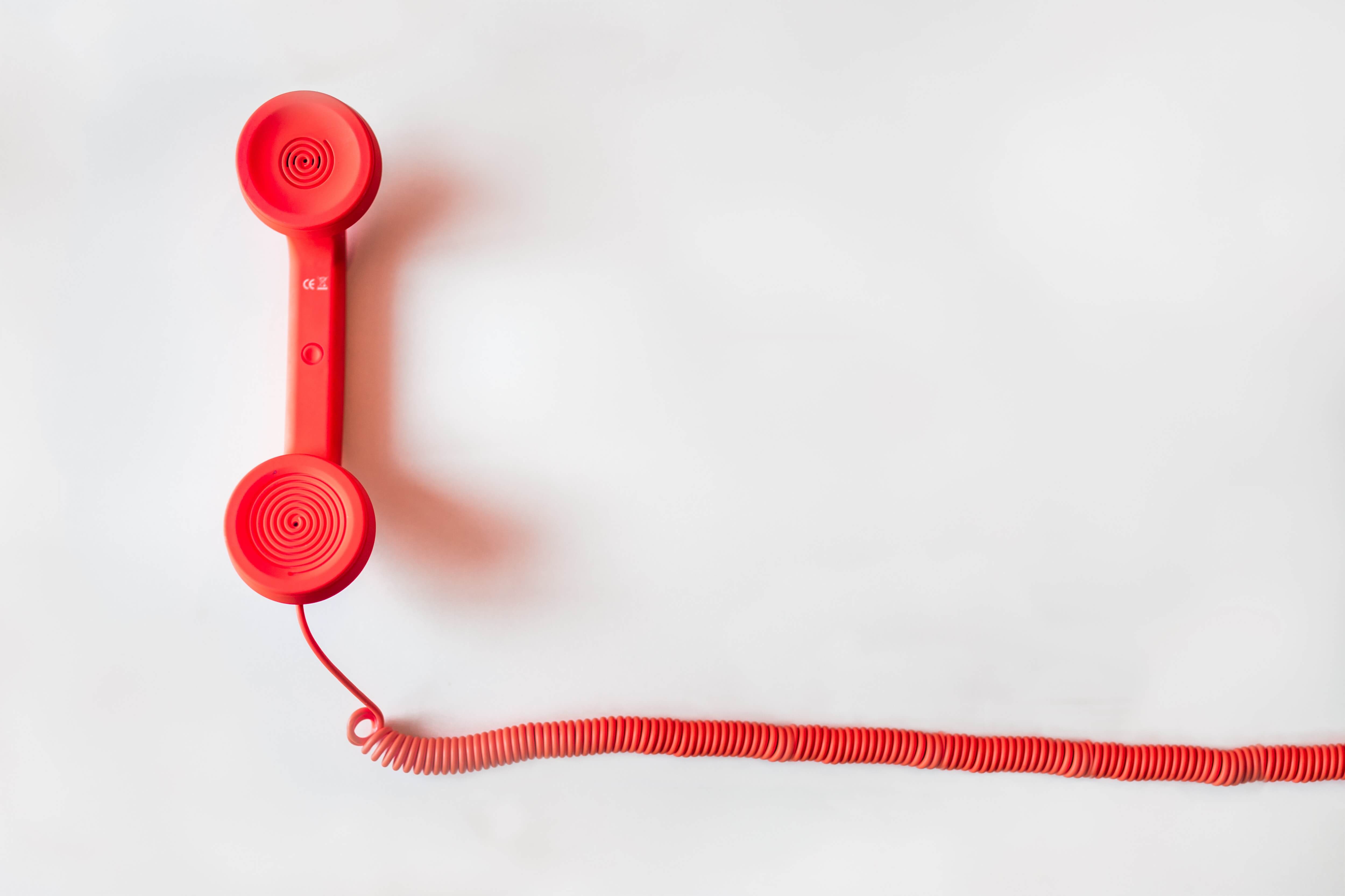 A red old-fashioned telephone off the hook